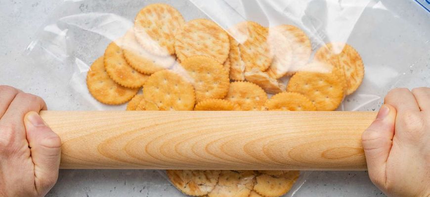 Crushing Ritz crackers in a bag with a rolling pin for a striped bass recipe